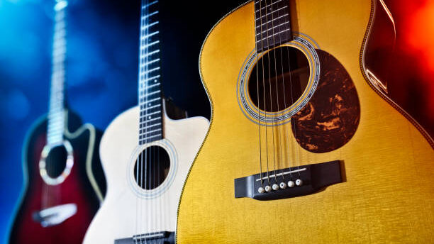 Three acoustic guitars on stage or in recording studio  background