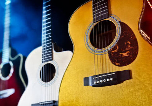 Three acoustic guitars on stage or in recording studio  background